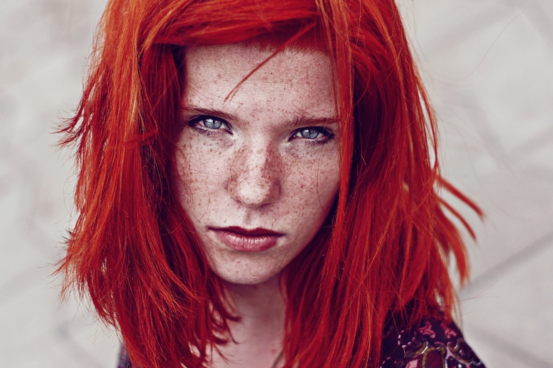 Фото рыжей женщины с яркими тату на светлой коже