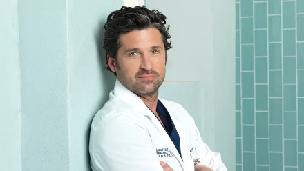 HD wallpaper featuring a character from Grey's Anatomy in a white lab coat posing confidently against a blue-tiled background.