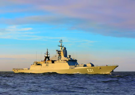 HD wallpaper of the Russian Navy corvette Soobrazitelnyy, a modern warship navigating calm seas under a colorful sky.