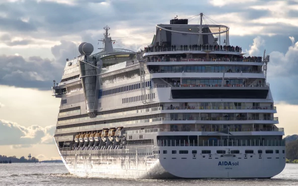 HD PC desktop wallpaper/background: AIDAsol cruise ship (vehicle) gliding through calm sea beneath a dramatic, cloud-filled sky.