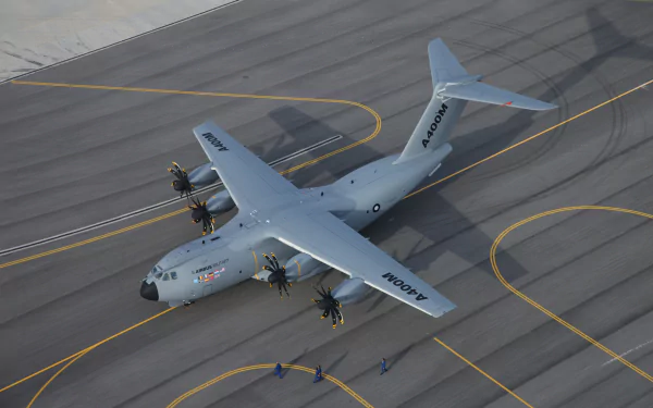 HD desktop wallpaper featuring an Airbus A400M military transport warplane on an airport tarmac, showcasing its four-engine design and robust structure.