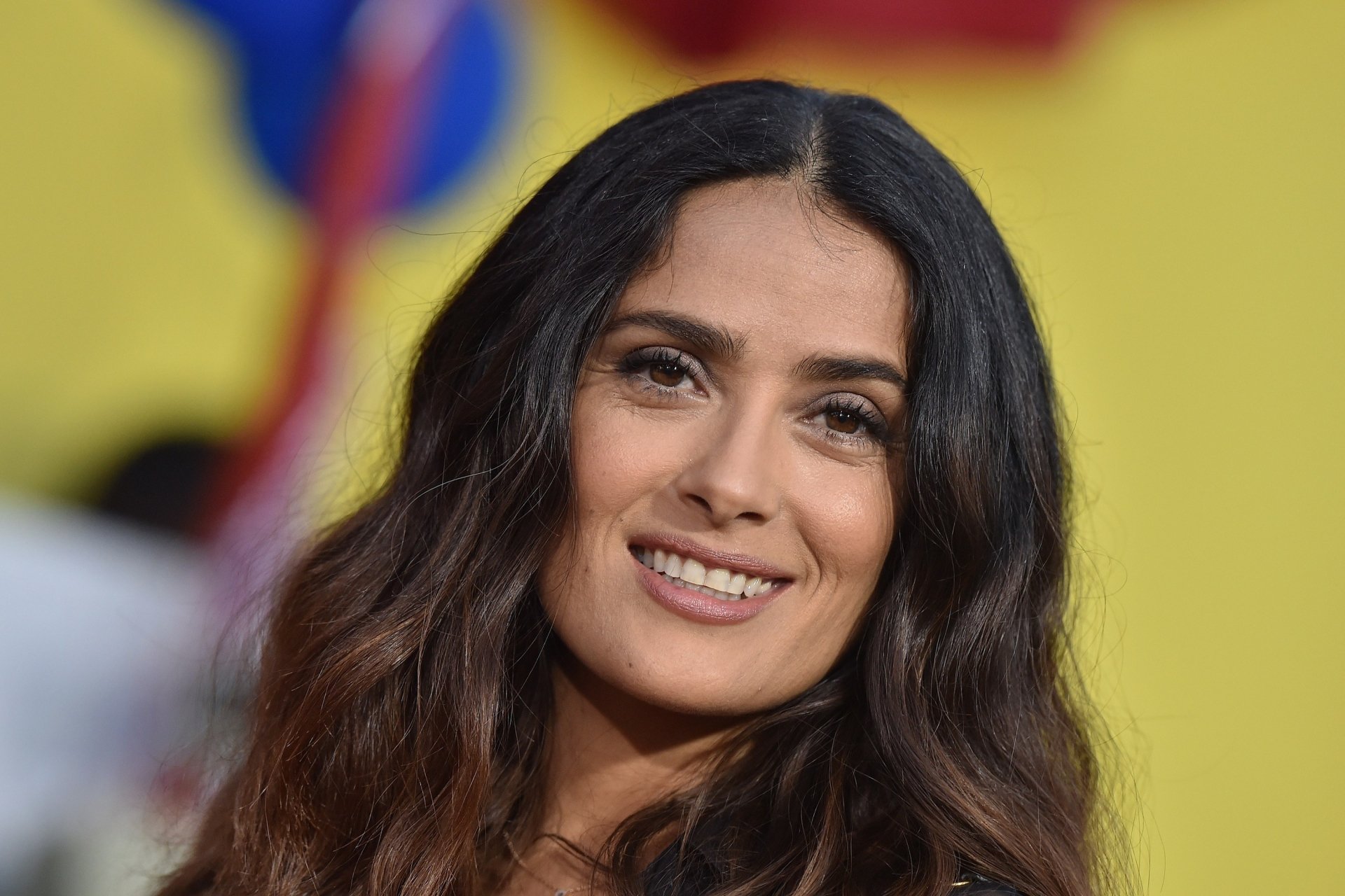 HD desktop wallpaper featuring a smiling Spanish actress with black hair and brown eyes, showcasing a close-up portrait of Salma Hayek.