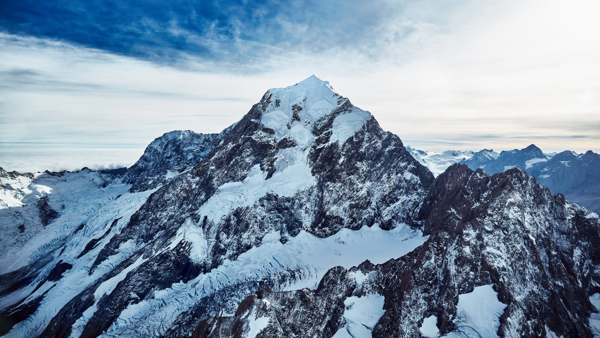 A stunning 4K Ultra HD desktop wallpaper featuring a majestic snow-covered mountain under a vibrant blue sky, showcasing pristine nature in a winter landscape.