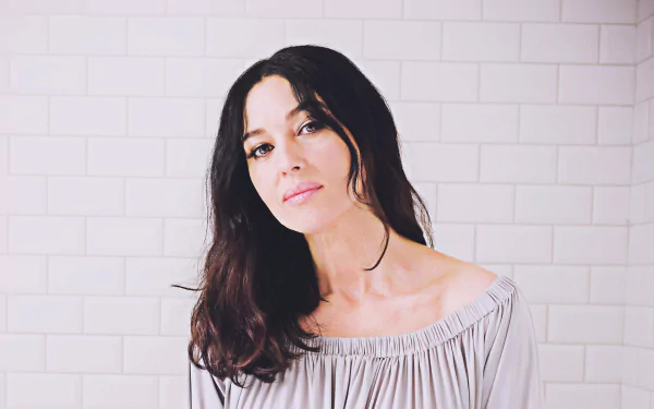 4K UHD desktop wallpaper: close-up portrait of an Italian woman with black hair and a soft, cinematic gaze, evoking a classic film actress against a pale tiled background.