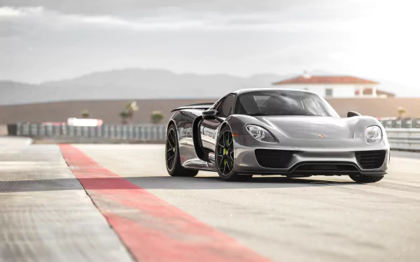 Silver Porsche 918 Spyder supercar on a racetrack, 5K Ultra HD PC desktop wallpaper and background showcasing its low, aerodynamic stance.