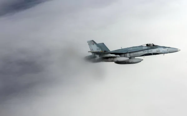 HD desktop wallpaper featuring a McDonnell Douglas CF-18 Hornet jet fighter soaring through cloudy skies in military flight.