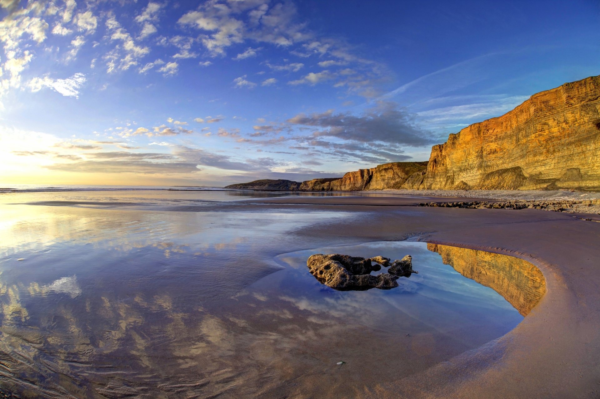 4K Ultra HD desktop wallpaper showing the Wales coastline with cliffs, ocean, beach, and a vivid horizon under a partly cloudy sky.