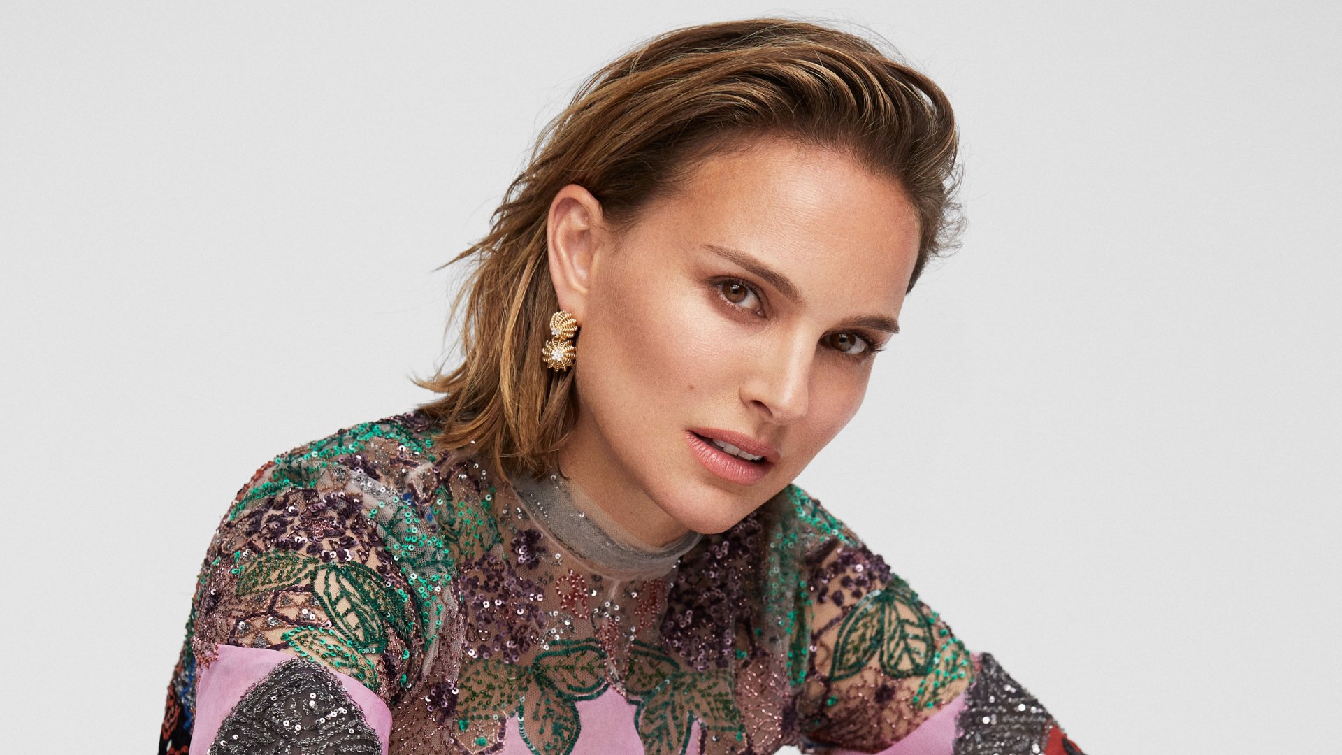 Close-up of Israeli actress and celebrity Natalie Portman wearing ornate earrings, featured in a 4K Ultra HD PC desktop wallpaper and background.
