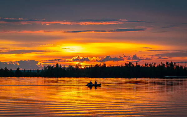 A serene 4K Ultra HD forest river at dusk with vibrant sunset colors reflecting on the water, featuring a silhouetted boat in the distance.