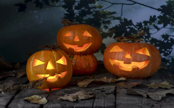 Three glowing jack-o'-lantern pumpkins sit on a wooden surface surrounded by fallen leaves, capturing a spooky fall Halloween scene in 4K Ultra HD.