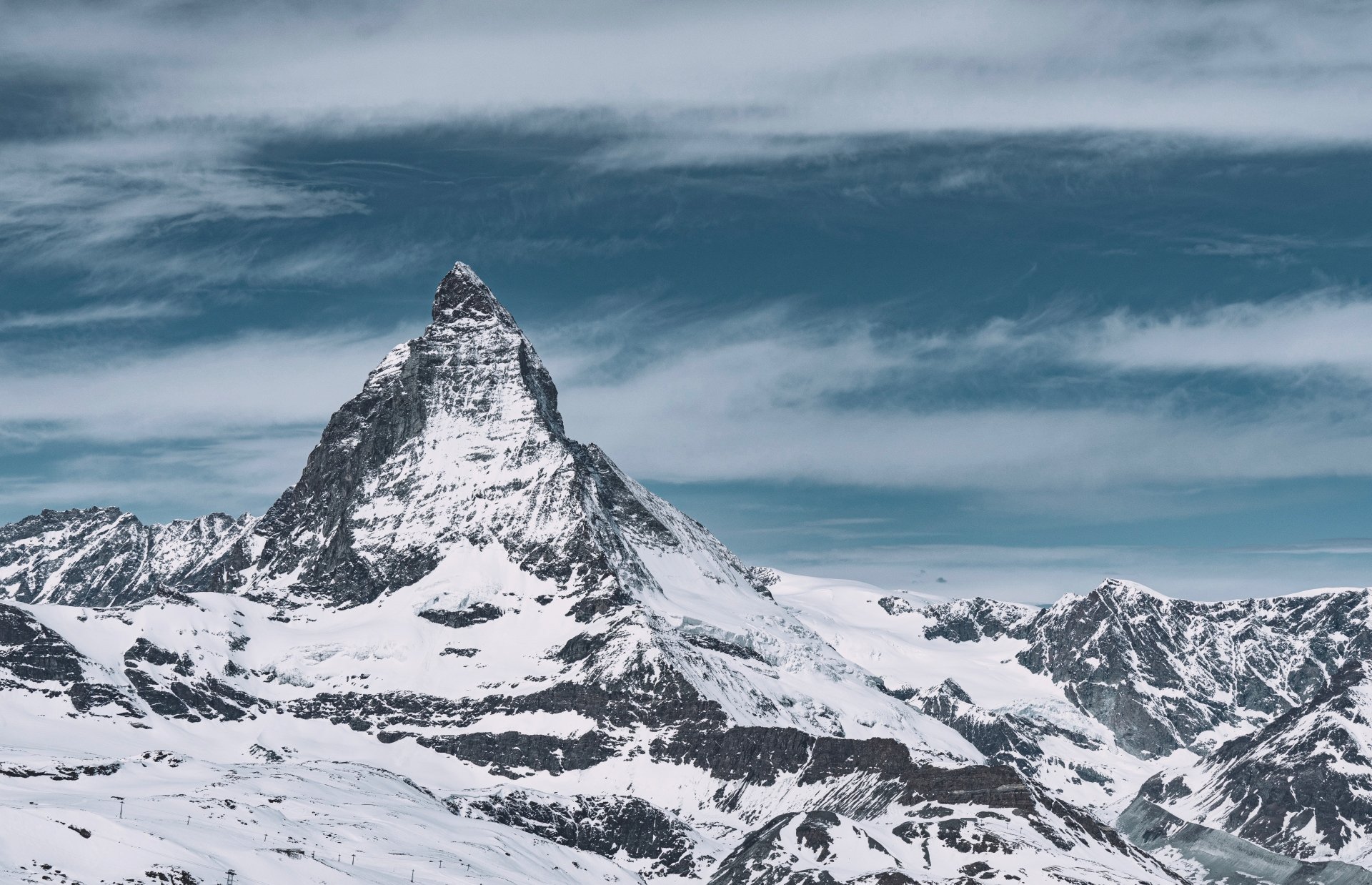 Snow-covered Matterhorn peak rises sharply against a cloudy sky in this stunning 4K Ultra HD winter mountain landscape.