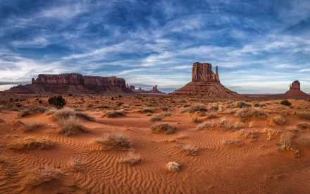 4K Ultra HD landscape of Monument Valley desert in the USA, showcasing red sand dunes under a dramatic sky as a stunning nature desktop wallpaper.