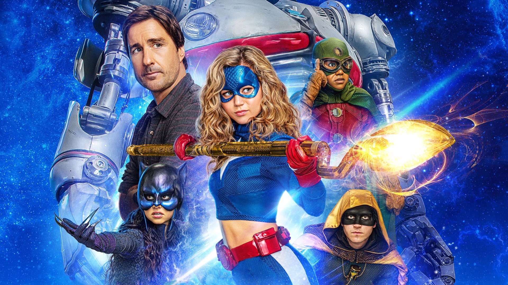 Stargirl (Courtney Whitmore) grips her cosmic staff center, flanked by Wildcat, Hourman, Doctor Mid‑Nite and S.T.R.I.P.E., cosmic blue 2K quad‑HD TV show wallpaper.