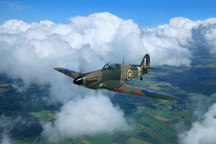 A Hawker Hurricane military warplane soars above clouds, captured in high-definition against a scenic aerial landscape.