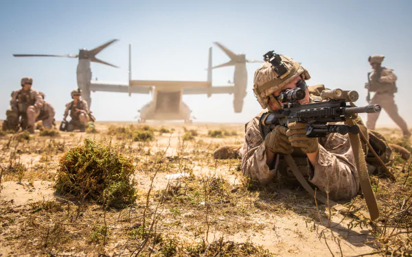 4K Ultra HD military wallpaper showing a soldier aiming a rifle while lying on desert terrain, with comrades and a tiltrotor aircraft in the background.