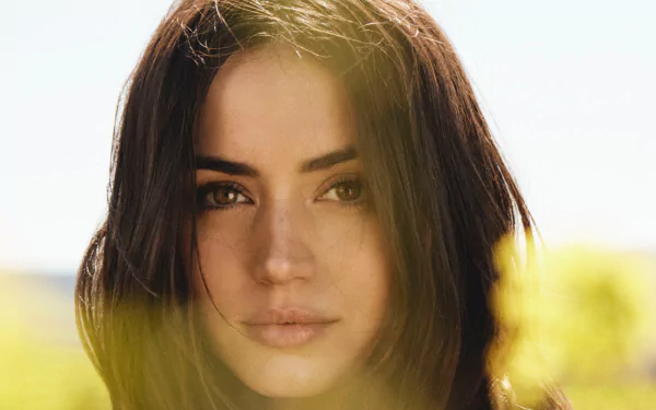 Close-up HD portrait of brunette Cuban actress Ana de Armas with soft natural lighting, capturing her face against a blurred outdoor background.