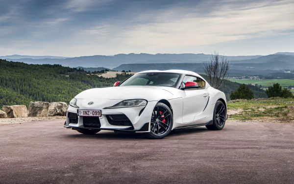 White Toyota GR Supra sports car on a scenic overlook, 4K Ultra HD PC desktop wallpaper background.