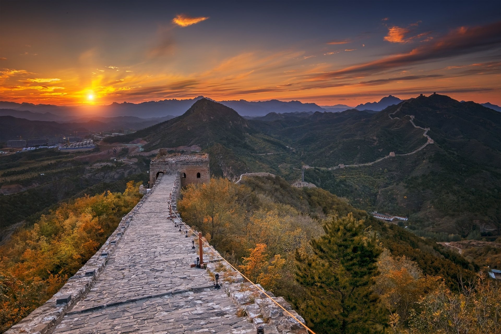 HD PC desktop wallpaper: the man-made Great Wall of China winding over mountains at sunset, stone ramparts glowing in golden light.