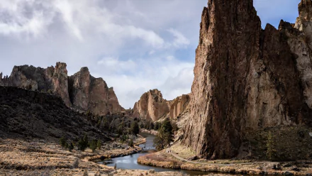 4K Ultra HD view of Smith Rock State Park, Oregon, featuring towering rock formations and a winding river under a cloudy sky in a natural landscape.