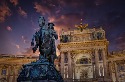 2K Quad HD PC desktop wallpaper: equestrian sculpture in foreground with ornate Vienna palace façade lit at twilight, Austria.