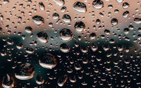Close-up photography of raindrops on glass, captured in stunning 4K Ultra HD detail, creating a crisp and reflective texture for a PC desktop background.