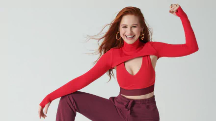 Redhead American actress Madelaine Petsch smiles confidently in a vibrant red outfit, captured in a sharp 4K Ultra HD desktop wallpaper.