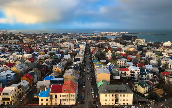 A vibrant cityscape of Reykjavik, Iceland, featuring colorful buildings and streets with the ocean in the background, captured in 4K Ultra HD for a desktop wallpaper.