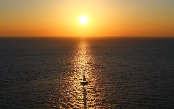 4K Ultra HD desktop wallpaper of a sailboat (ship/vehicle) heading toward the sun on the horizon, its sail and shadow reflected across the golden sea.