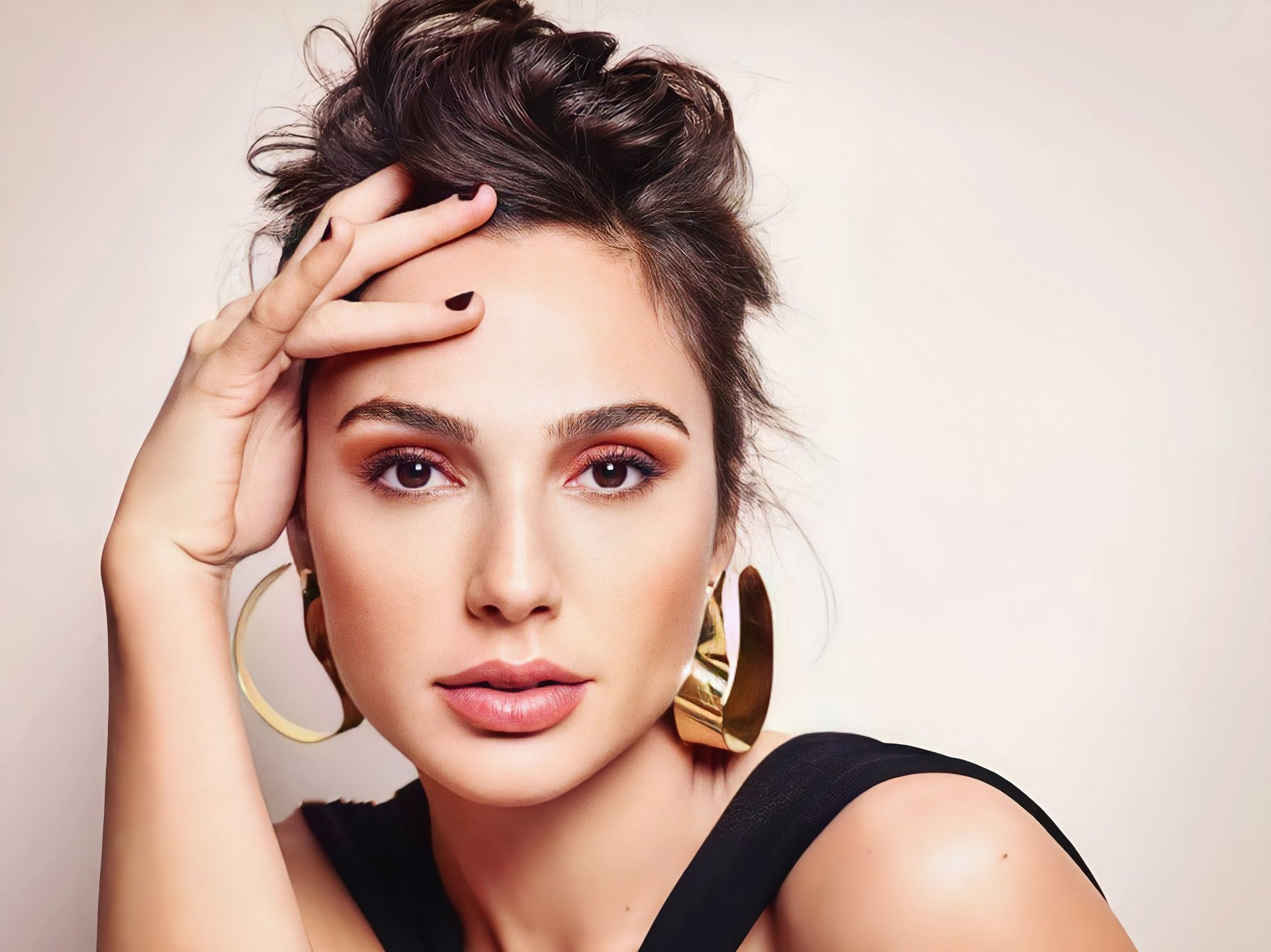4K Ultra HD PC wallpaper: close-up portrait of a brunette woman with brown eyes, large hoop earrings and a hand near her face, studio-lit facial detail.