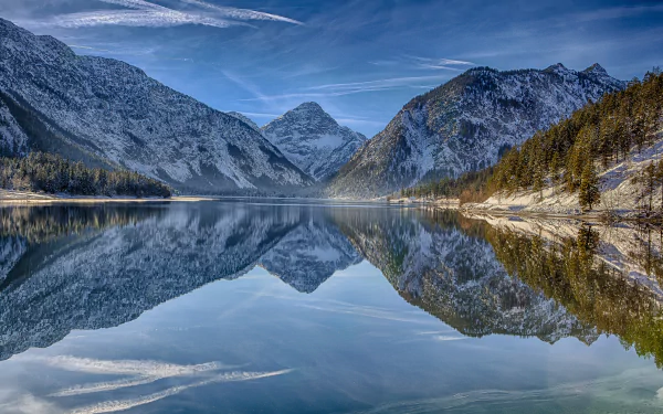 HD desktop wallpaper of Lake Plansee in Tirol, Austria, showcasing alpine mountains and their clear reflections on the tranquil lake surface in the heart of the Alps.