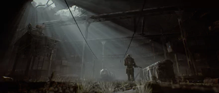 HD PC desktop wallpaper from the video game S.T.A.L.K.E.R. 2: Heart of Chernobyl, depicting a lone figure exploring a dark, abandoned industrial interior lit by rays of light.