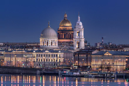 Saint Isaac's Cathedral and neoclassical riverside architecture in Saint Petersburg at evening, golden domes lit and reflected on the river — HD desktop wallpaper.