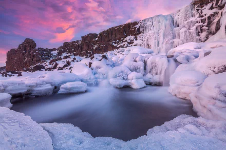 Öxarárfoss waterfall in Iceland's national park at winter sunset — icy cascades and frozen pools beneath a pink‑purple sky. HD PC desktop wallpaper and background.