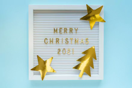 HD desktop wallpaper: white framed letterboard reading Merry Christmas 2021 with gold glitter stars and a tree on pale blue — holiday number-themed design.