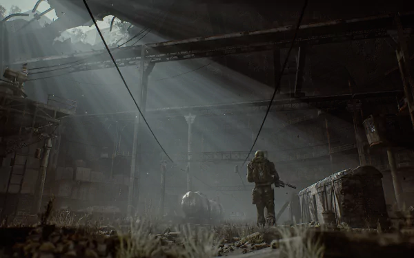 HD PC desktop wallpaper from the video game S.T.A.L.K.E.R. 2: Heart of Chernobyl, depicting a lone figure exploring a dark, abandoned industrial interior lit by rays of light.
