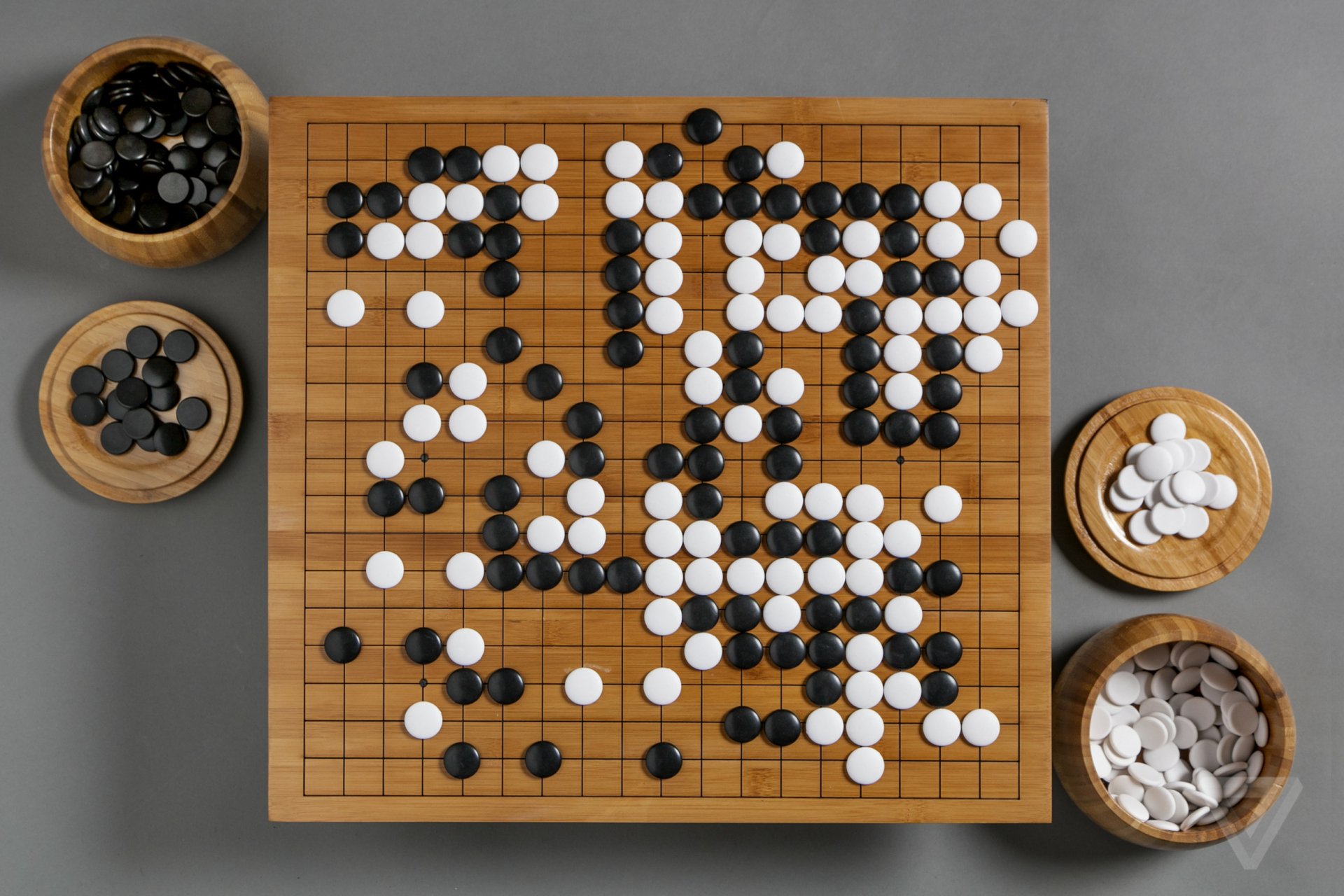 HD desktop wallpaper featuring an overhead view of a Go game in progress with black and white stones on the wooden board.