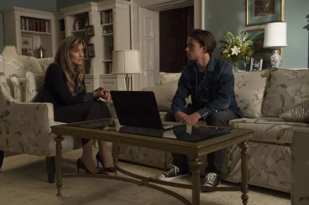 HD wallpaper featuring Tanner Buchanan and a co-star in a living room scene with a laptop on a coffee table.