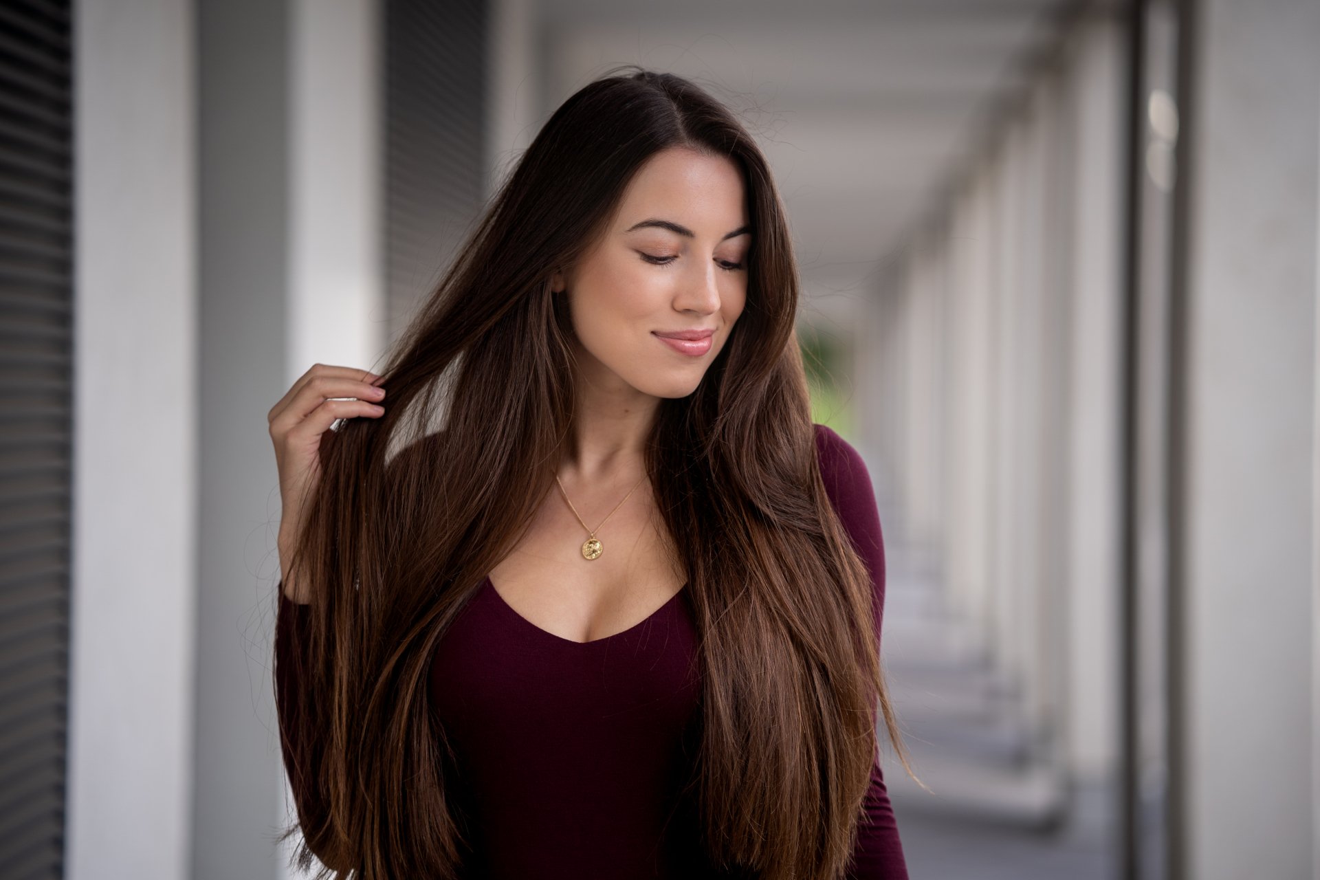 Brunette woman with long hair stands in a depth of field setting, captured in a 4K Ultra HD PC desktop wallpaper and background style.