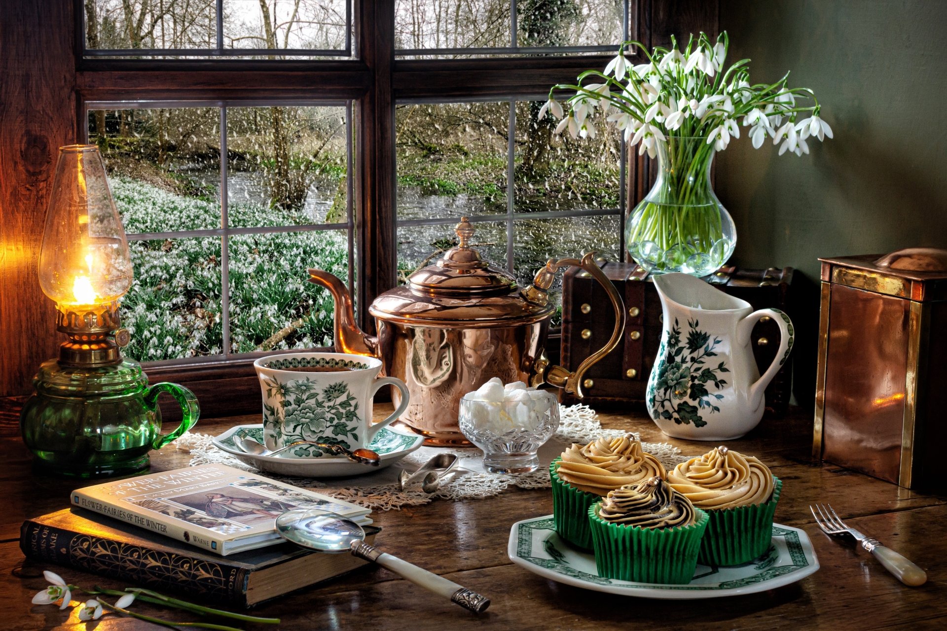 5K Ultra HD PC desktop wallpaper and background — still life photography: cupcakes, pitcher of snowdrops, teacup, lamp, book and copper teapot on a window table.