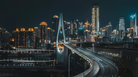 HD desktop wallpaper showing a night view of a bridge leading into the illuminated skyscrapers of Chongqing, China, highlighting the city's modern architecture.