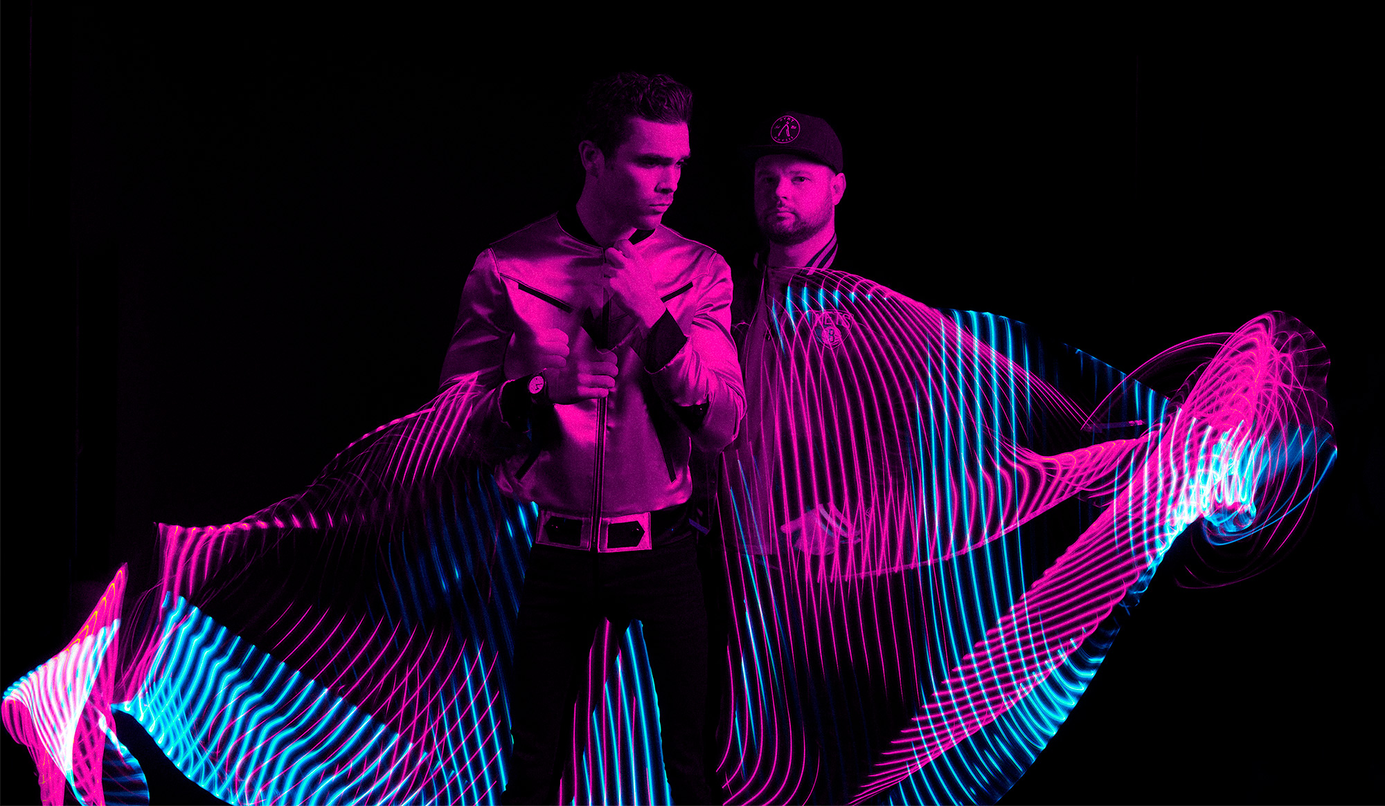 HD desktop wallpaper featuring two members of Royal Blood with dynamic neon light trails on a dark background