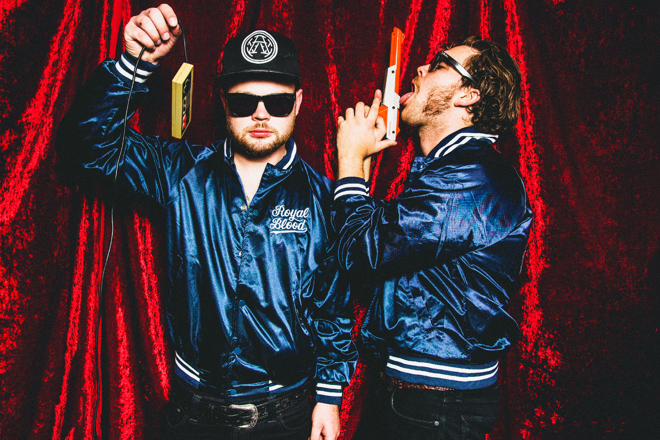 HD desktop wallpaper featuring two members of Royal Blood in stylish jackets against a red velvet background, exuding a cool and edgy vibe.