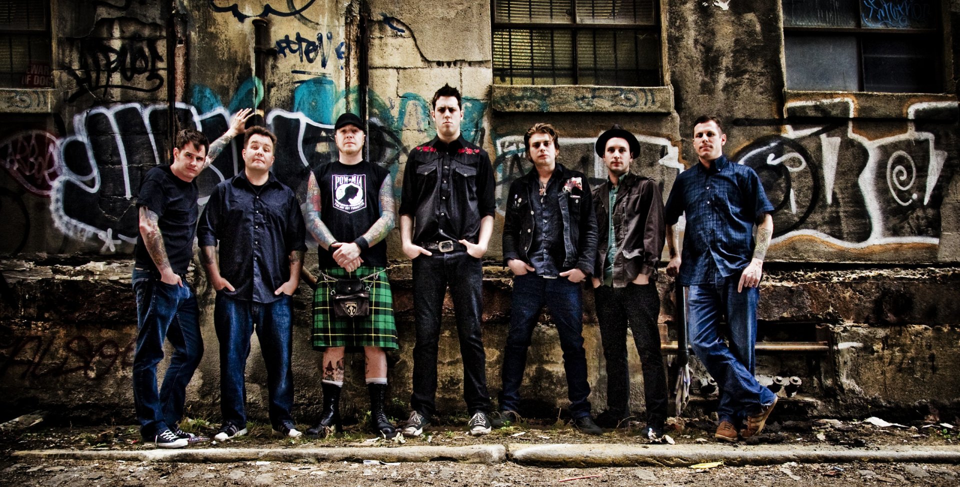 HD wallpaper featuring Dropkick Murphys band members posing confidently in front of a graffiti-covered wall for a desktop background.