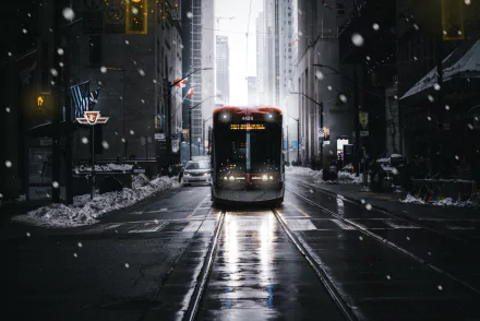 A 4K Ultra HD PC desktop wallpaper featuring a tram traveling down snowy city streets at dusk, with tall buildings and glowing streetlights creating an urban winter scene.