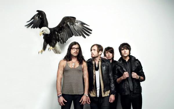 HD desktop wallpaper featuring the band Kings Of Leon with a flying eagle above them, against a white background.
