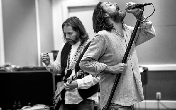 HD wallpaper featuring The Black Crowes with one member singing into a microphone and another playing guitar, in monochrome.