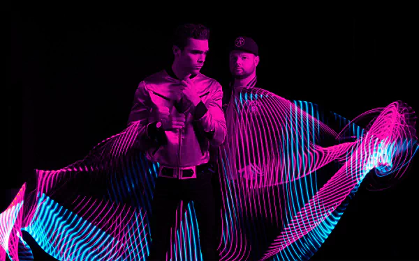 HD desktop wallpaper featuring two members of Royal Blood with dynamic neon light trails on a dark background