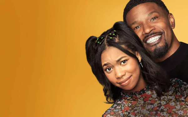 A vibrant wallpaper featuring Jamie Foxx and a co-star from the TV show Dad Stop Embarrassing Me, set against a warm, yellow background. Their cheerful expressions highlight the show's comedic vibe.