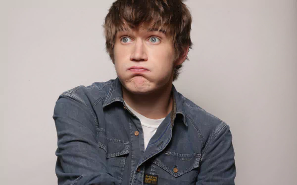 Quirky expression HD wallpaper featuring a young man in a denim shirt for desktop background.