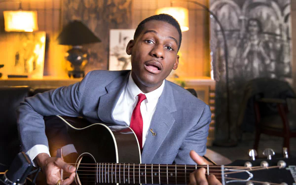HD desktop wallpaper and background featuring a musician with a guitar, sitting in a vintage-styled room.